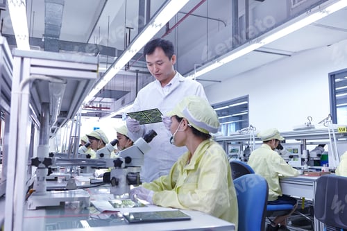 Preview: Supervisor overseeing quality check station at factory producing flexible electronic circuit boards.