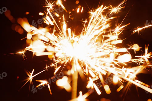 Preview: Close-up of golden blurry sparks burn in the dark