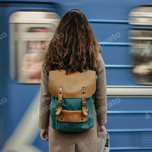 Preview: Young woman girl traveller in front of train in metro, motion blur