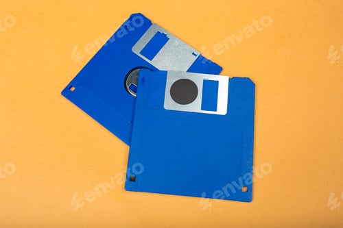 Preview: Old blue floppy disks on orange background showing storage technology from past decades