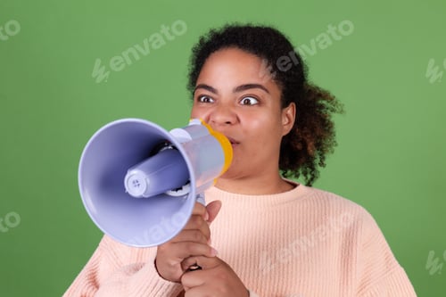 Preview: Beautiful african american woman on green background screaming shouting in megaphone ask attention