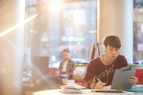Preview: Asian student working in the library
