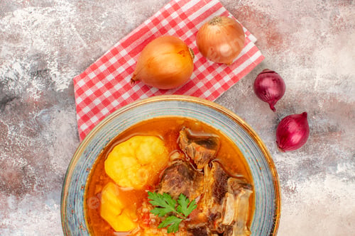 Preview: top close view bozbash soup kitchen towel yellow and red onions on nude background azerbaijani
