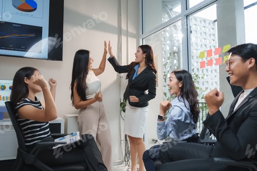 Preview: Excited business team celebrating successful project giving high five in office meeting