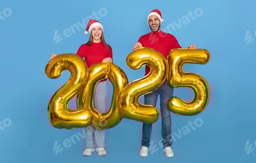 Visualização: Jovem casal alegre usando chapéus de Papai Noel segurando balões dourados de 2025 nas mãos