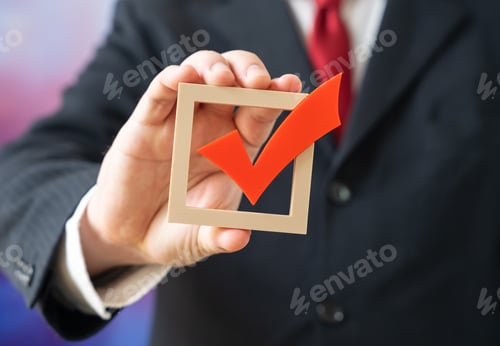Preview: An official holds a voting check mark symbolizing elections and power struggle. Candidate legitimacy