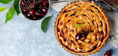 Preview: Homemade open cherry pie with lattice on a gray concrete background. Selective focus. Top view