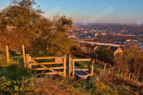 Preview: Old wooden fence and the town of Batley in West Yorkshire under the blue sky