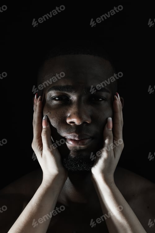 Preview: close-up of a black African-American man's face with a white Caucasian woman's hands on his cheeks