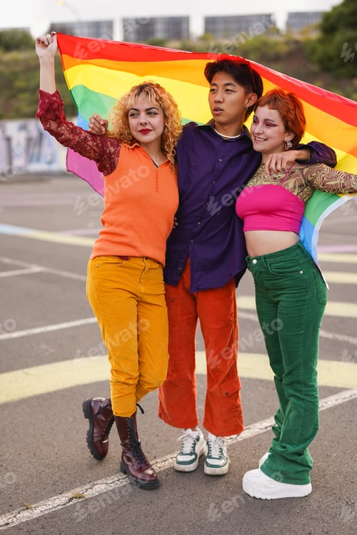 Preview: Happy diverse people having fun together at LGBT pride parade holding rainbow flag