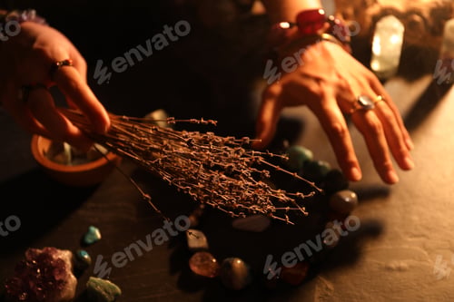 Preview: Woman doing ritual with healing stones at dark table, closeup