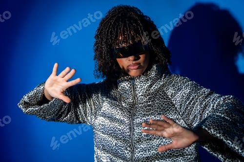 Preview: Stylish dancer moving with hands up on blue background