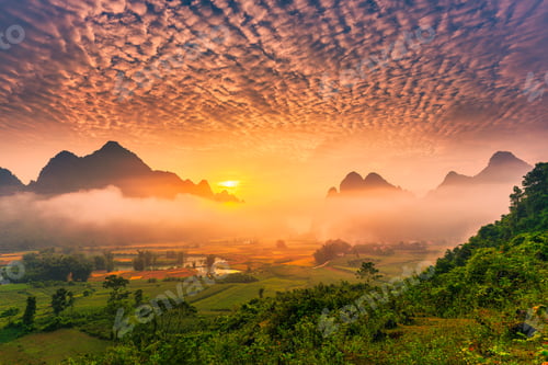 Preview: Sunrise over mountain range with foggy, river and traditional village in Phong Nam Valley