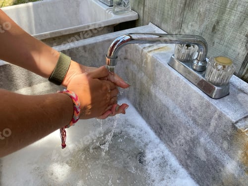 Preview: Close-up of a young person man, woman, washing his hands in a laver in the summer