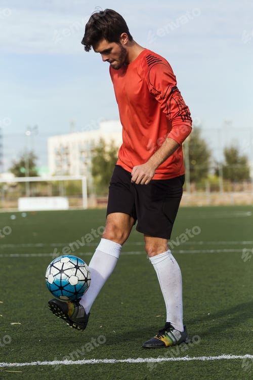 Vista previa: Jugador de fútbol pateando una pelota