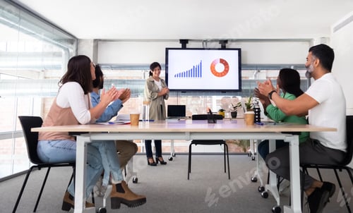 Preview: Group of multiracial coworkers celebrate great company result applauding together.