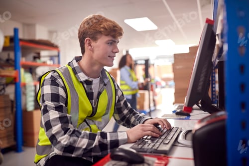 Preview: Male Intern Working In Busy Modern Warehouse On Computer Terminal