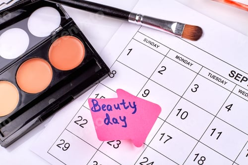 Preview: Beauty day concept. Cosmetic powder with brush and calendar.