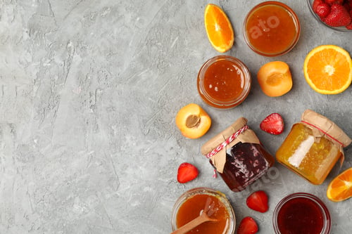 Preview: Glass jars with jam and ingredients on gray background, top view
