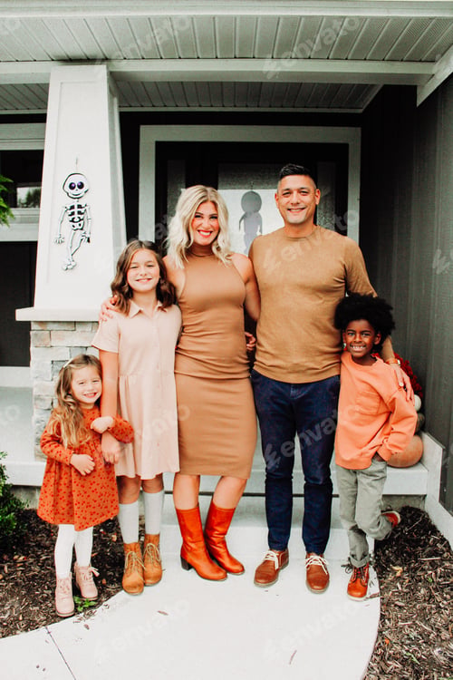 Family Standing Together Outside of their Suburban Home