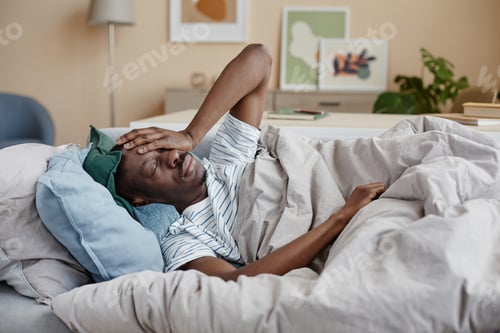 Preview: View of African American man in blankets struggling with depression