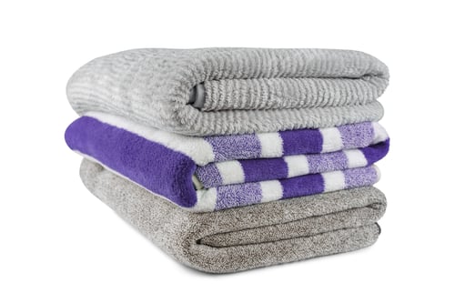 Preview: Soft Fluffy Striped Grey And Purple Bath Towels Folded In Stack Isolated On White Background