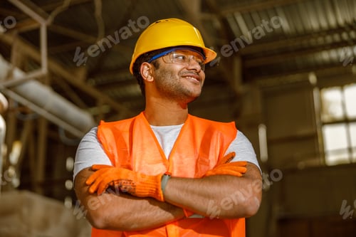 Preview: Happy African engineer standing at industrial site