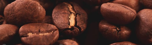 Preview: Coffee lover view of roasted coffee beans for background and texture. Dumped roasted coffee beans