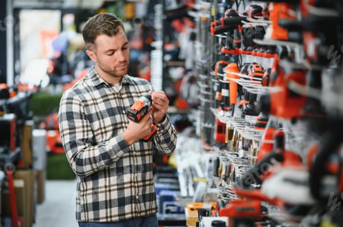 Preview: A man chooses a power tool in a hardware store