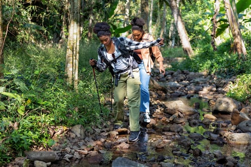 Preview: Backpack tourist travel hiking outdoor adventure walking in row on rock side of water stream flow