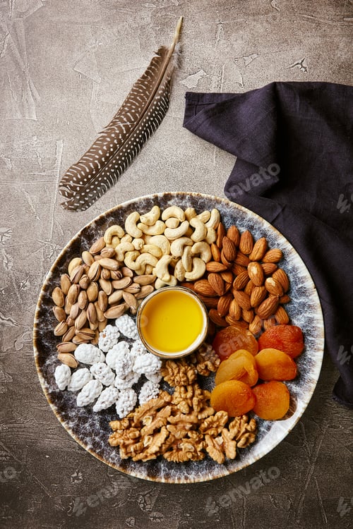 Preview: Assorted nuts and dried fruits in oriental style on a platter - dried apricots, cashews, pistachios