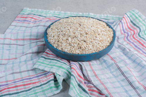 Preview: Heap of flakes filled into a large tray on a towel on marble background