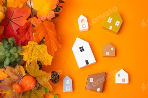 Preview: Miniature houses and autumn leaves on orange background