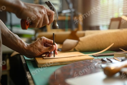 Preview: Professional craftsman using a hammer and other tools to shape and detail the leather piece