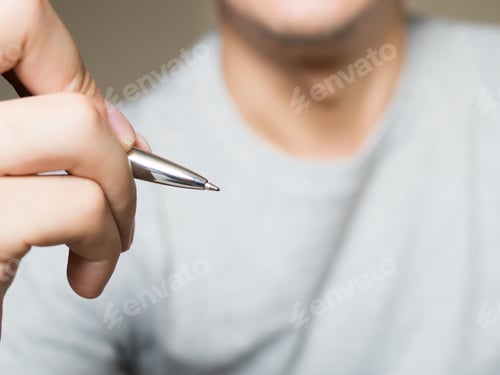 Preview: Man holding pen, writing and drawing in the air with copy space