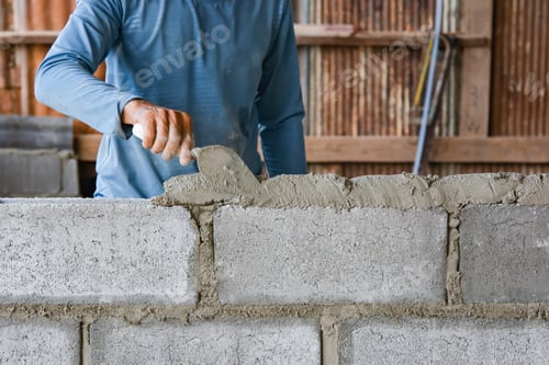Preview: Bricklayer laying bricks on mortar