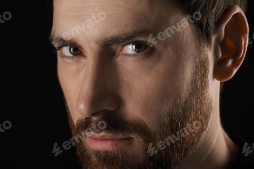 Preview: Evil eye. Man with scary eyes on black background, closeup