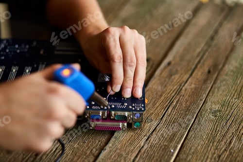 Preview: Engineer or technician repair electronic circuit board with soldering iron.