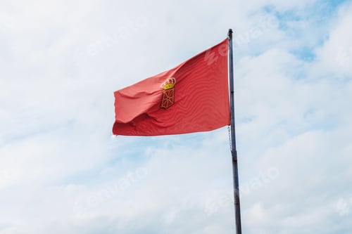 Preview: Flag of Navarra, Spain, waving in the wind on clear sky background.