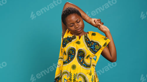 Preview: Natural sweet woman stretching her back and arms muscles in studio