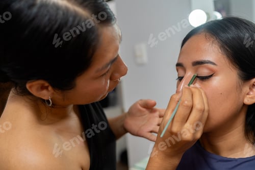 Preview: Makeup artist applying eyeliner to young latina woman