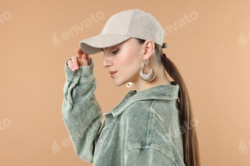 Preview: Beautiful woman in stylish baseball hat on beige background