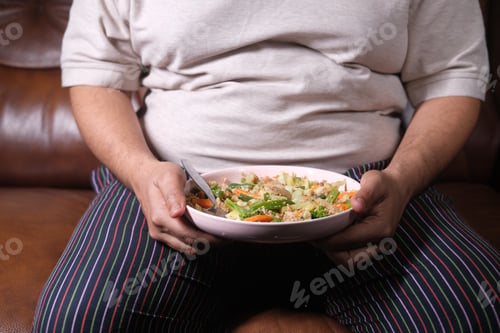 Preview: a fat men in casual dress eating fresh salad , healthy food concept