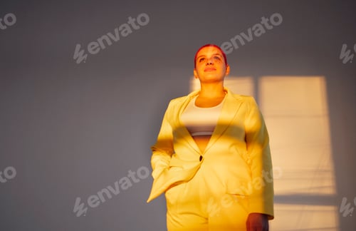 Preview: Beautiful relaxed woman in yellow suit and red shot hair holding hand behind head