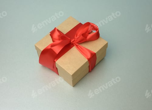 Preview: Square box wrapped in brown kraft paper and tied with red silk ribbon