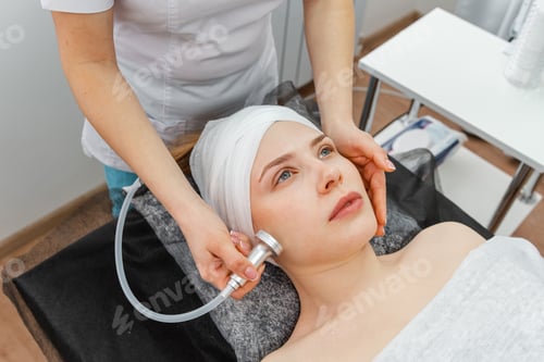 Preview: Young smiling woman cosmetologist with roller doing buttocks massage