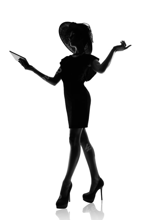 Preview: Studio shot of a stylish woman in silhouette using a digital table against a white background