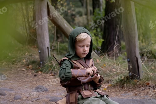 Preview: Portrait of a boy in a medieval costume holding a bow against a forest background