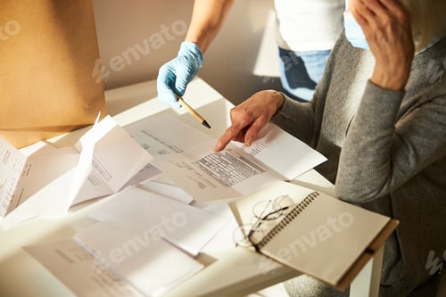 Preview: Senior woman and her caretaker scrutinizing utility bills