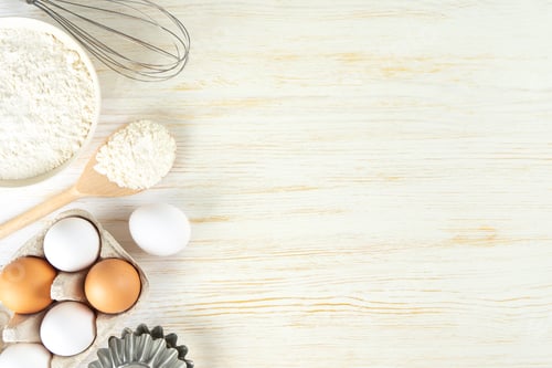 Preview: Baking ingredients flour, eggs, milk, bakeware on white wooden background with copy space
